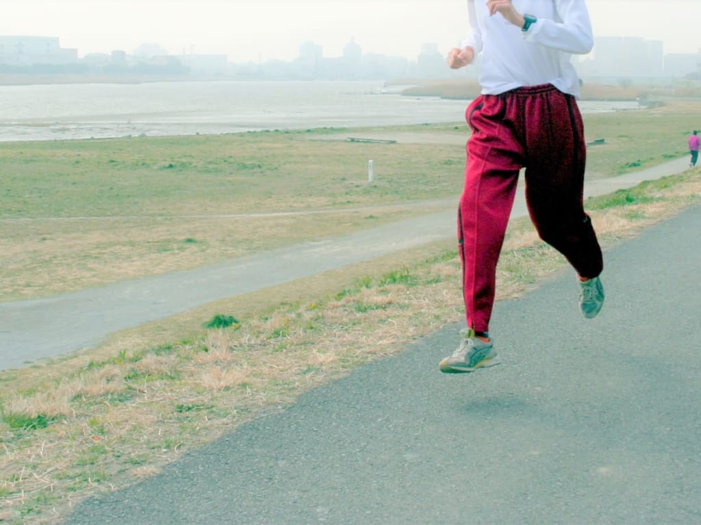 河川敷を走るマラソンランナー